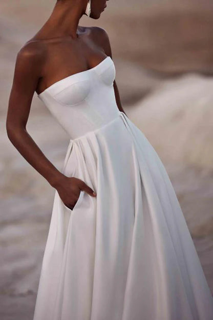 A white satin wedding dress with palace train lines and no shoulder straps