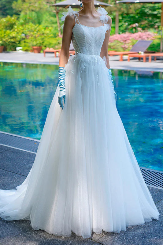 A simple wedding dress with thin shoulder straps, spoonful beads, and a single thread